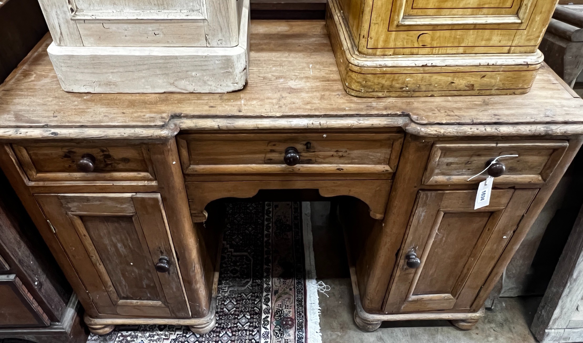 A Victorian pine inverse breakfront kneehole desk, width 119cm depth 49cm height 77cm